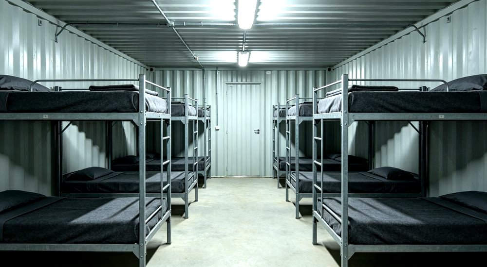 Eye-level interior of shipping container converted to mining dormitory with grey bedding on bunk beds for remote mine site worker accommodation Eye-level interior of shipping container converted to mining dormitory with grey bedding on bunk beds for remote mine site worker accommodation