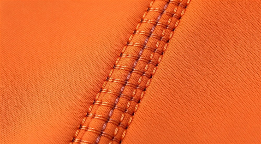 Macro product detail of blind stitch seam construction on neoprene wetsuit showing sealed stitching technique that minimizes water exchange and maximizes thermal insulation for water rescue Macro product detail of blind stitch seam construction on neoprene wetsuit showing sealed stitching technique that minimizes water exchange and maximizes thermal insulation for water rescue