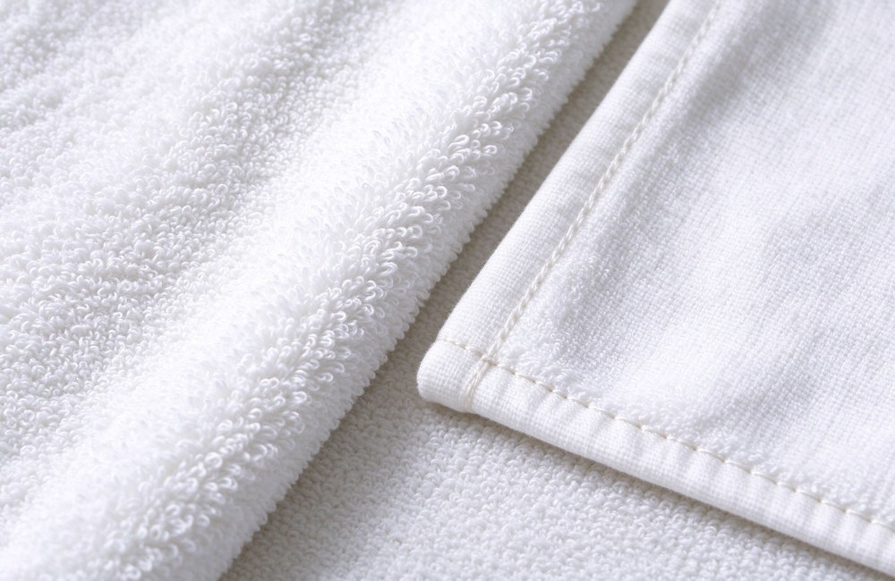 Macro closeup comparing dense terry loops and smoother weave on white cotton towels with neat stitched hems yarn count hotel spa towels fabric detail quality control hotel spa towels wholesale factory direct China supply bulk order Macro closeup comparing dense terry loops and smoother weave on white cotton towels with neat stitched hems yarn count hotel spa towels fabric detail quality control hotel spa towels wholesale factory direct China supply bulk order