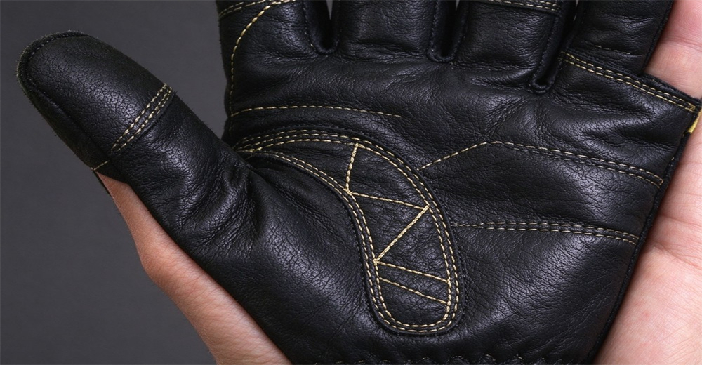 Close up shot of black leather fire safety glove palm area with reinforced geometric yellow stitching for abrasion resistance Close up shot of black leather fire safety glove palm area with reinforced geometric yellow stitching for abrasion resistance