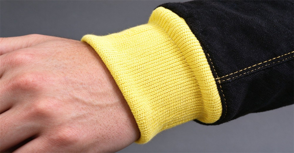 Close up view of fire resistant protective glove featuring stretch yellow knitted cuff and black leather outer layer with neat stitching Close up view of fire resistant protective glove featuring stretch yellow knitted cuff and black leather outer layer with neat stitching