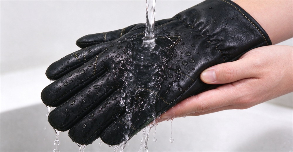 Water flows over the surface of black fire protective glove to demonstrate its water resistant performance Water flows over the surface of black fire protective glove to demonstrate its water resistant performance